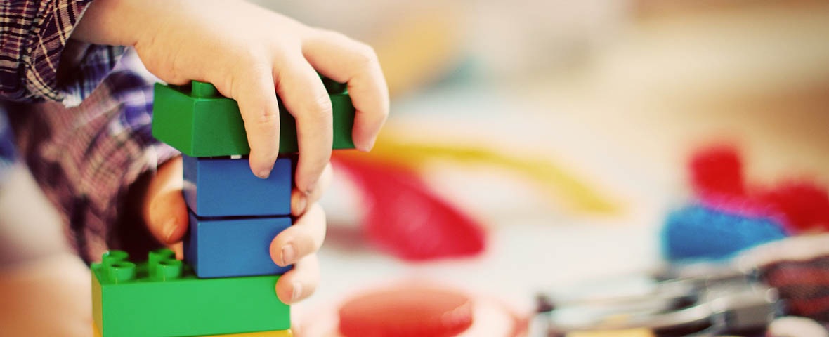 Kinderhände, mit Noppensteinen bauen