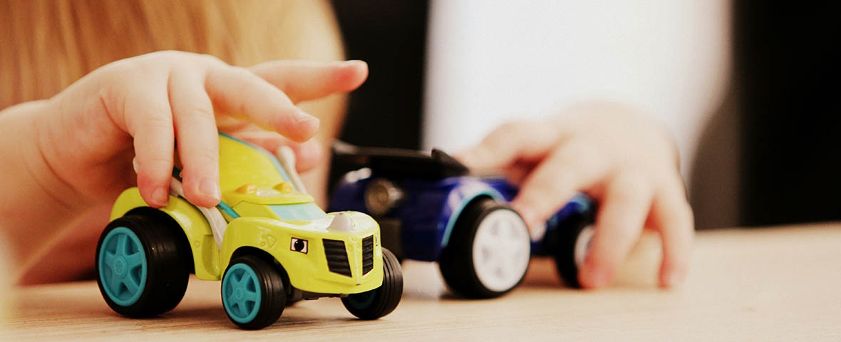 Kind spielt mit zwei Modellautos