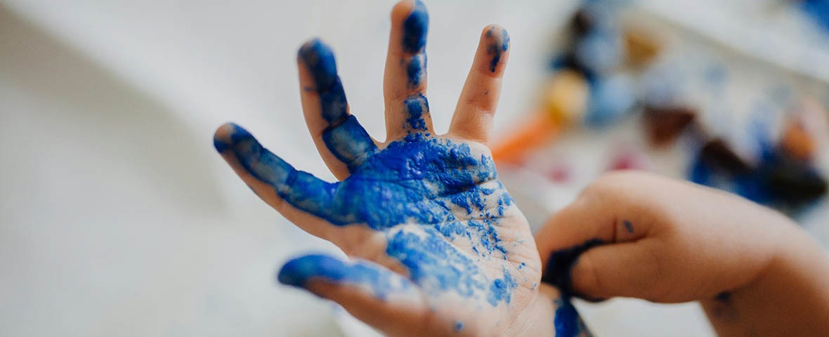 Kinderhand mit blauer Farbe