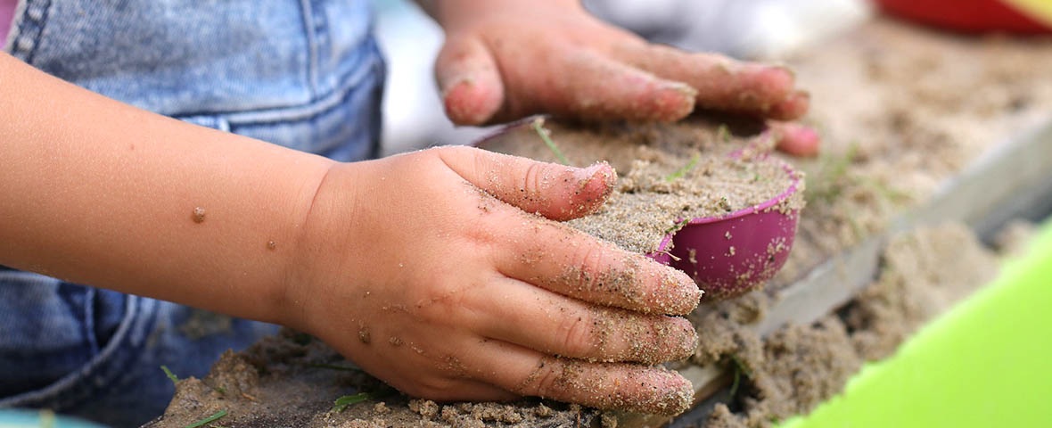 Kinderhände mit Sandspielzeug